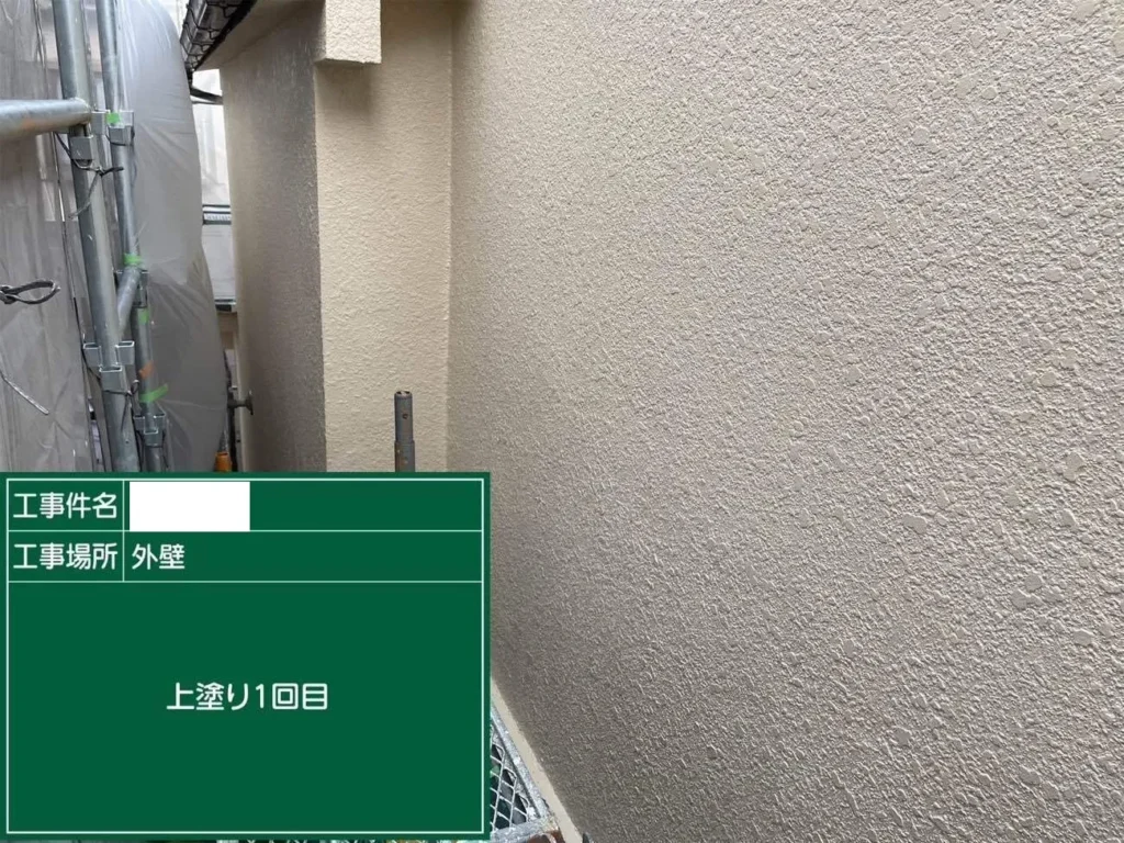 K様邸の外壁リフォームで行った外壁塗装の上塗り1回目の施工風景